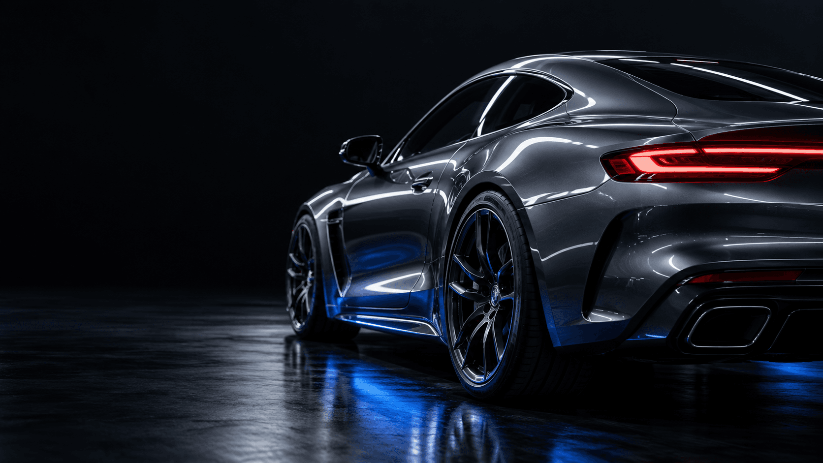 Graphite coupe rear quarter and wheel under cobalt studio light